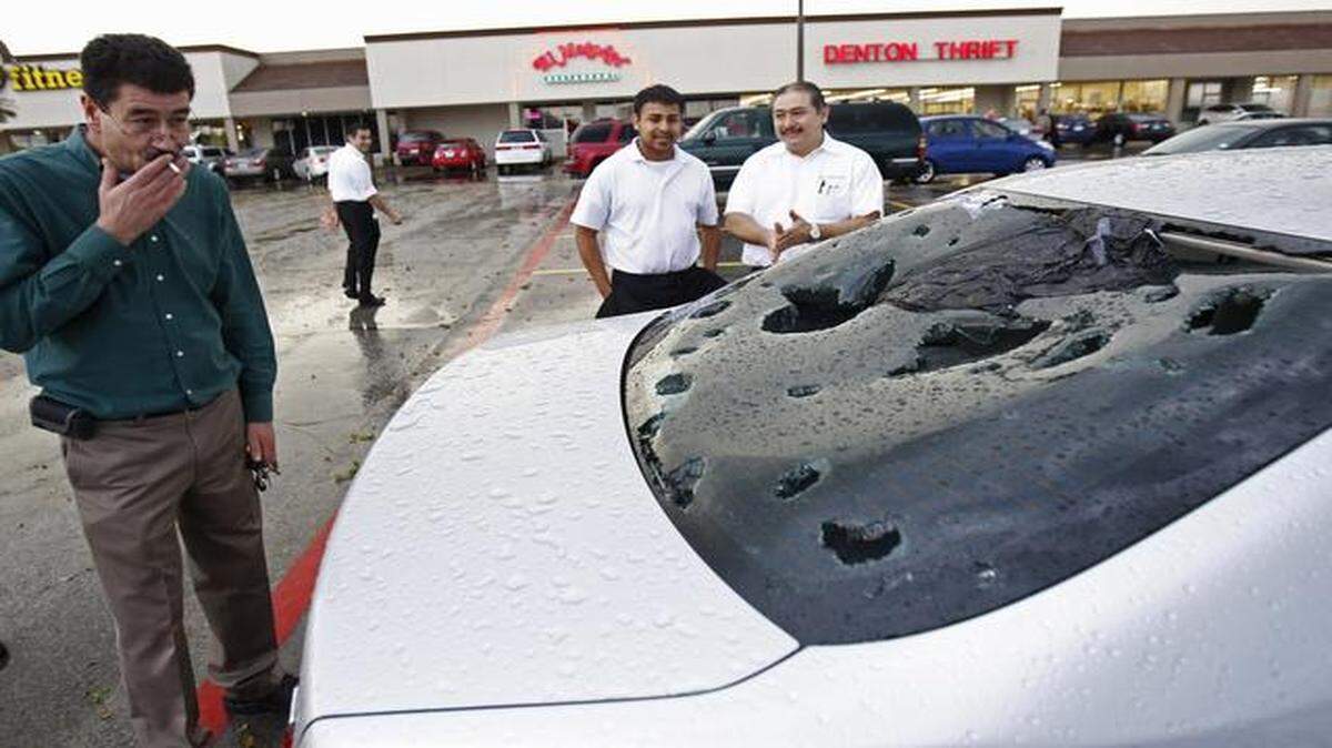 
Pablo Loza looked at hail damage to his car in a parking lot outside a thrift store in Denton, Texas.
