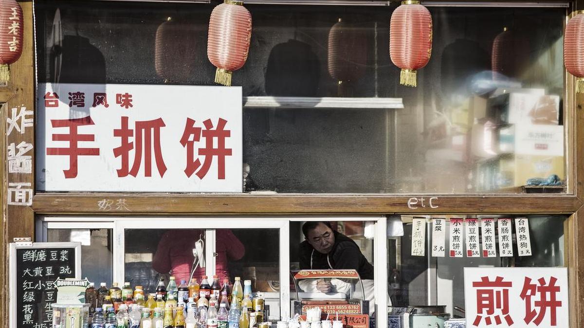At a food store in Beijing, a shopkeeper on Tuesday looked out a window.