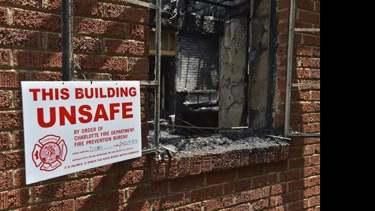 A sign warning the building is unsafe hangs outside the charred remains of Briar Creek Road Baptist Church Wednesday, June 24, 2015 in Charlotte, N.C. Investigators with the Charlotte Fire Department say a fire at the predominantly black church is a case of arson. The church's congregation is predominantly black, and there are about 100 members. Investigators are not sure if the fire was racially motivated. (Davie Hinshaw/The Charlotte Observer via AP) MAGS OUT; TV OUT; NEWSPAPER INTERNET ONLY
