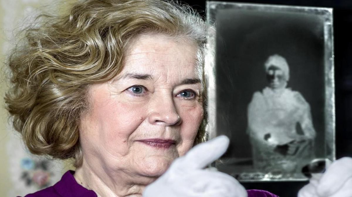 Mary Ann Brown looked at a photographic portrait of a woman on a glass-plate negative at the Leavenworth County Historical Society in the Carroll Mansion Museum. Brown, a volunteer and board member, is leading the society’s campaign to recover thousands of glass-plate negatives for its collection.