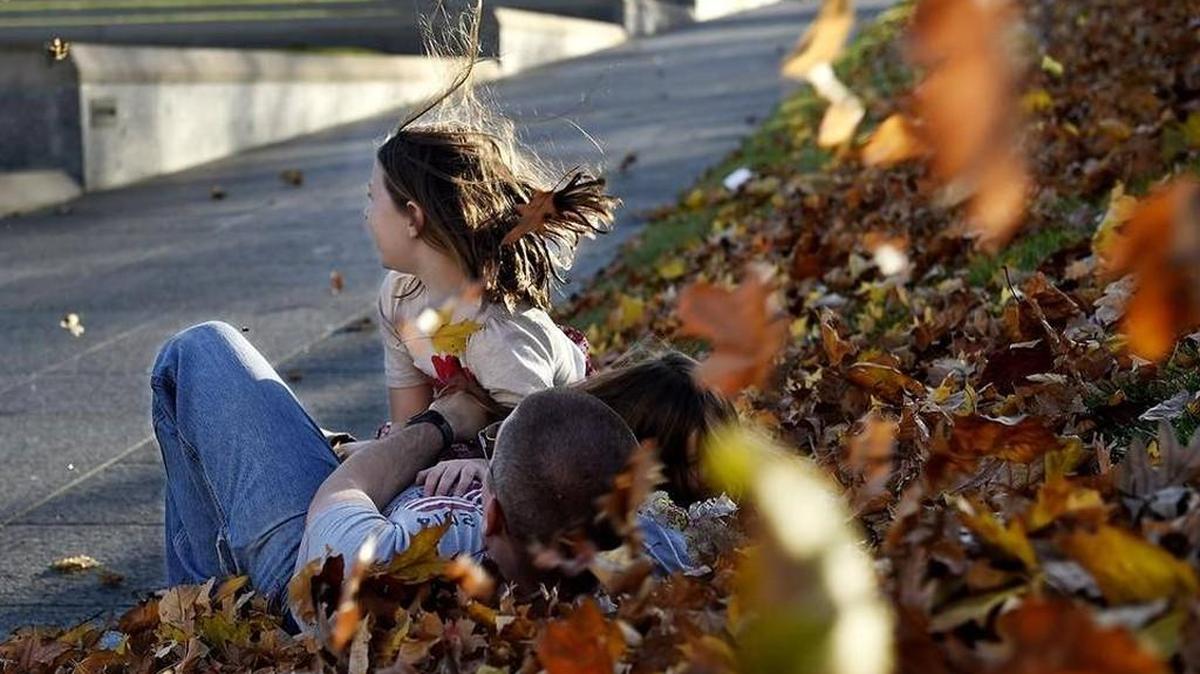 As gusty winds whipped up leaves Wednesday afternoon, Eric Wienke frolicked with his daughters, Lina, 7 (middle) and Clare, 4, on the grounds of the WWI Museum. Wienke, along with his wife Katy, traveled from Whiteman Air Force Base, where he is stationed, to visit the museum on Veterans Day. Wienke is a staff sergeant in the Contracting Squadron.