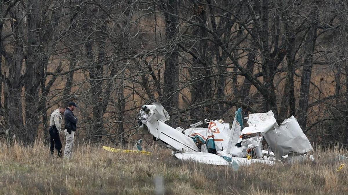 Officials investigate the scene of a plane crash on Monday morning that occurred Sunday in a field in Stone County, near Branson, Mo. The crash killed newlyweds Dawn Curtis, 45, and Keith M. Curtis Sr., 52, of Gardner, Kan.