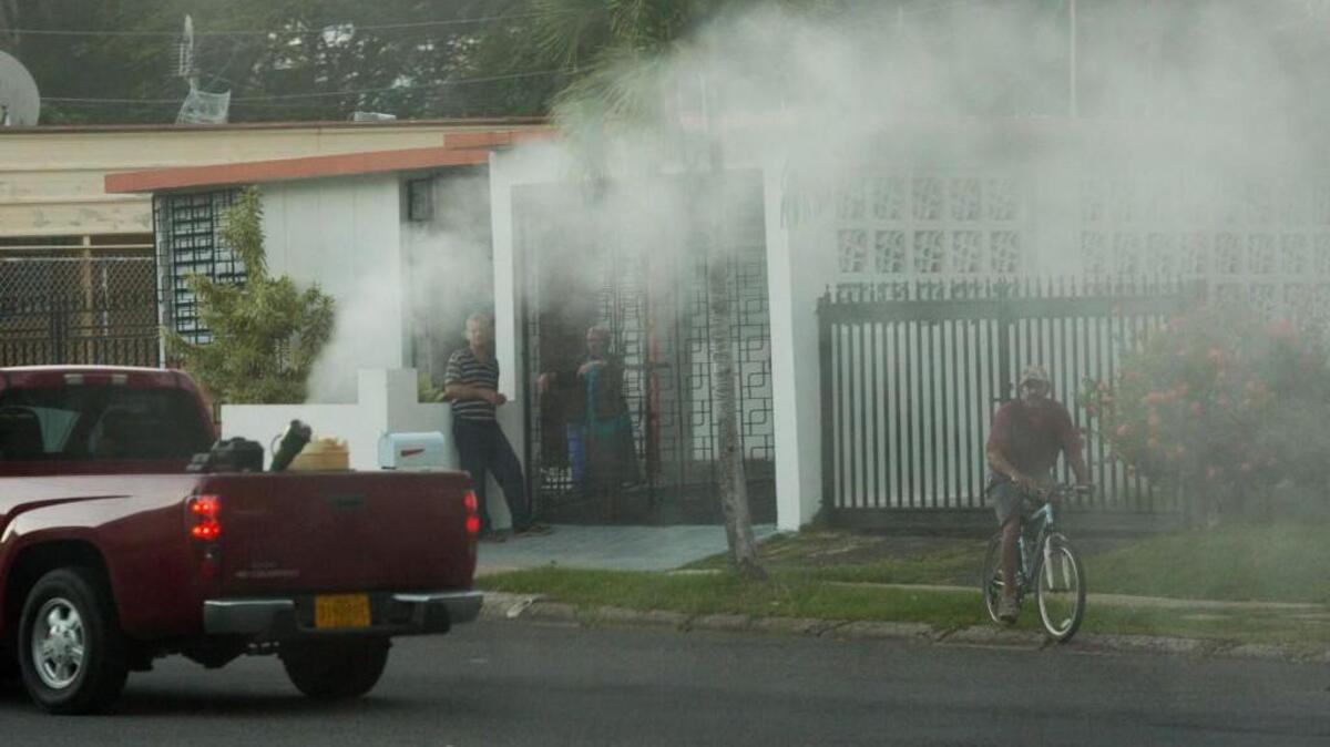 Residents are blanketed in a cloud of permethrin as a team from the Puerto Rico department of health sprays the insecticide the neighborhood of Cupey, in San Juan, Puerto Rico.