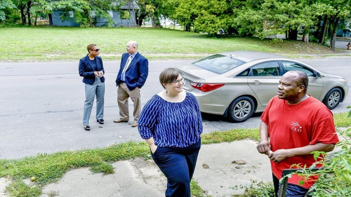Fresh Coast Capital co-founder April Mendez (center, facing camera) discussed with urban core resident Leaven Fountain (right) on Sept. 17, 2015, the possibility of turning the vacant lot in the background, at 18th Street and Cypress Avenue in Kansas City, into a tree-filled landscape. Behind Mendez and Fountain are Land Bank executive director Ted Anderson (right), who is teaming with Mendez to try to plant trees in vacant neglected lots, and Kimiko Gilmore, assistant city manager for Kansas City.