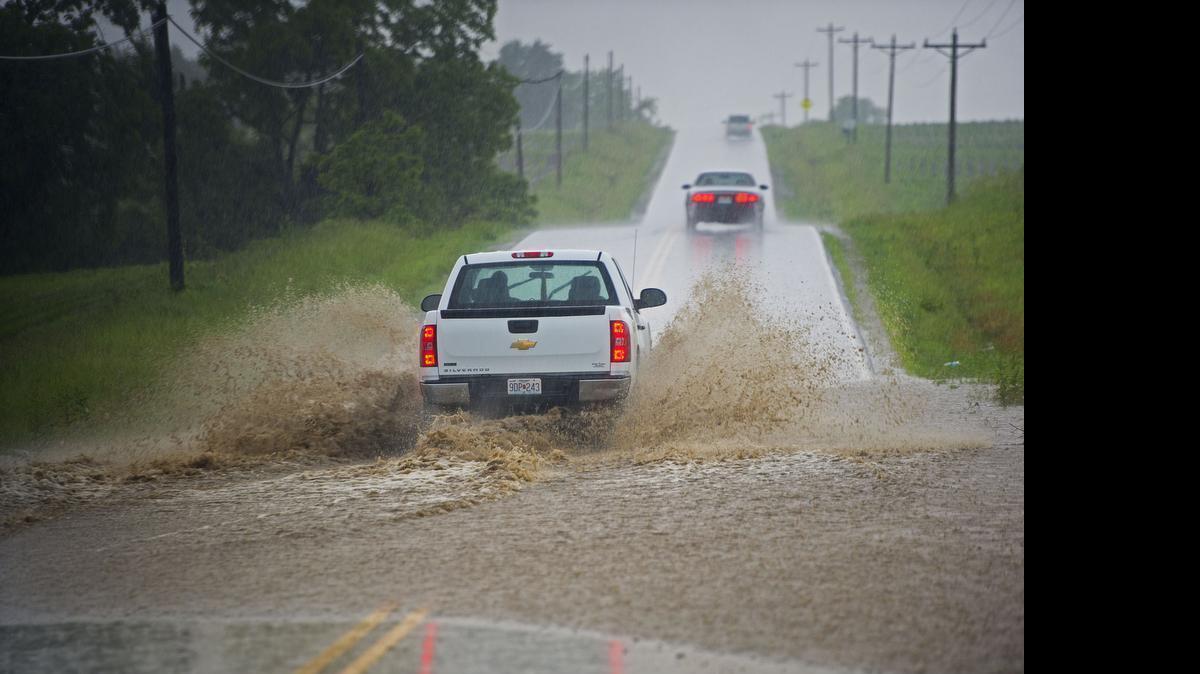 
As heavy rain fell, cars drove through water flowing over Missouri 131 near Varner Road near Odessa, Mo., on Wednesday, June 3, 2015.

