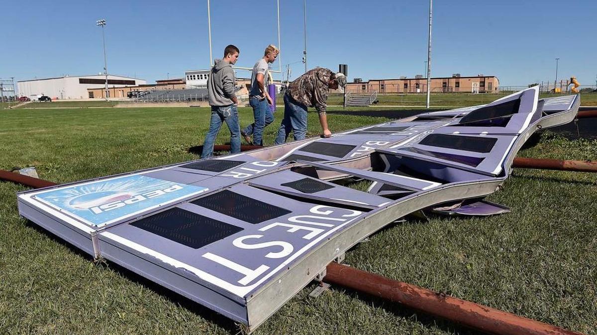 
Shortly before a Friday night football game, a tornado touched down at the Cass Midway School grounds in Cleveland, Mo., sending about 350 people inside to seek shelter. On Saturday, Cass Midway High School senior Jarett Jurgeson (cq) (from left), and recent graduates Jasper Love and Richard White inspected the scoreboard downed during the tornado. Jurgeson, who is on the football team, said the team was preparing for the game and Love and White were at the field to watch.
