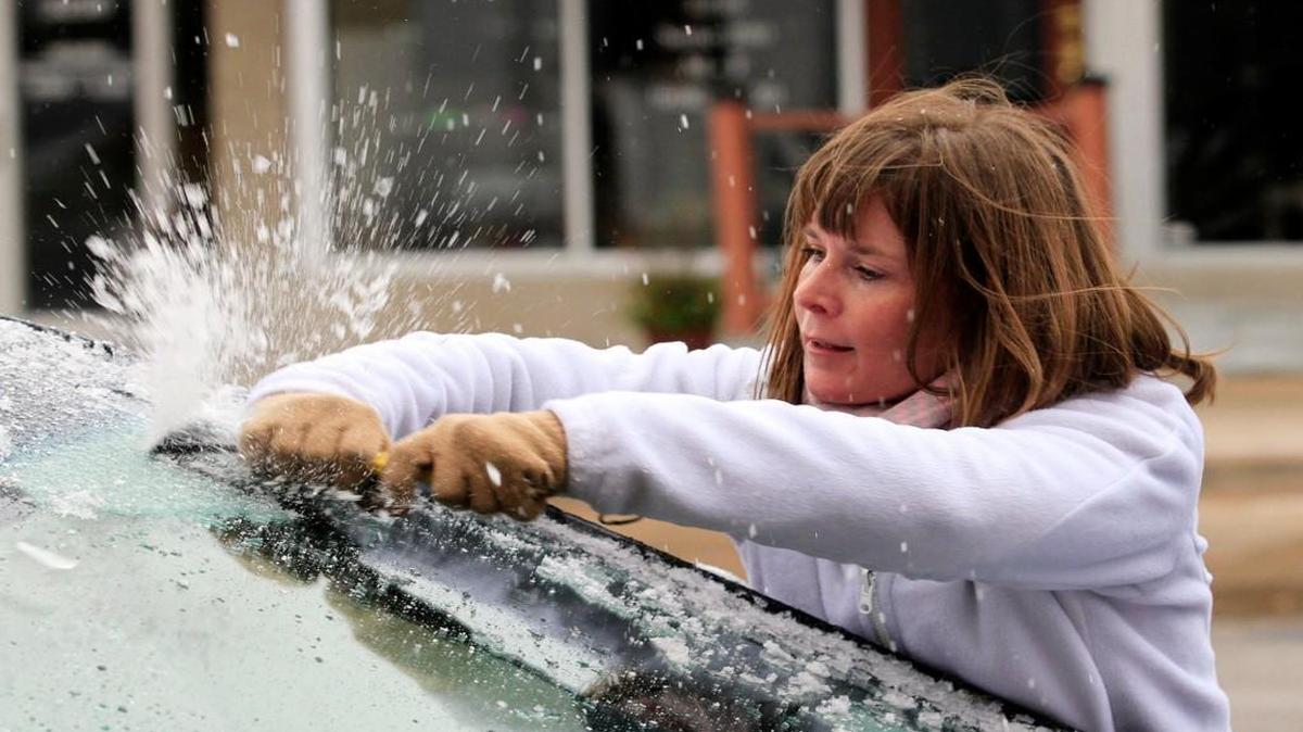 Krystal Wright scraped ice from her car’s windshield in Wichita. Winter weather left a layer of ice on roads and cars from the Kansas City area southwest through Kansas, Oklahoma and the Texas Panhandle, causes numerous wrecks.