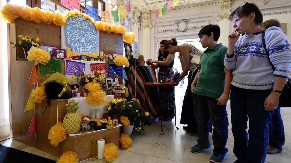 Dorri Partain of Kansas City (right) and her son Ian admire an altar inside the Kansas City Museum during a past Dia de los Muertos celebration.