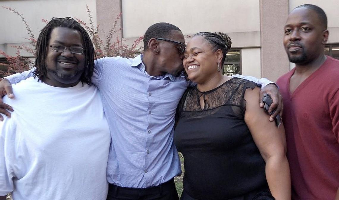 Shortly after being exonerated, Lamonte McIntyre, 41, kissed his sister, Glasia Lee, while posing with his brothers, Jermaine McIntyre, left, and Reginald McIntyre, right, outside of the Wyandotte County Courthouse on Friday, Oct. 13, 2017.