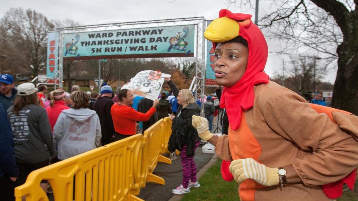 Volunteer Evette Edmondson of Riverside cheered on the runners Thursday at the fifth annual Ward Parkway Thanksgiving Day 5K Run/Walk. Proceeds benefited Harvesters and The Single MOM KC, an organization that provides resources for area single mothers.