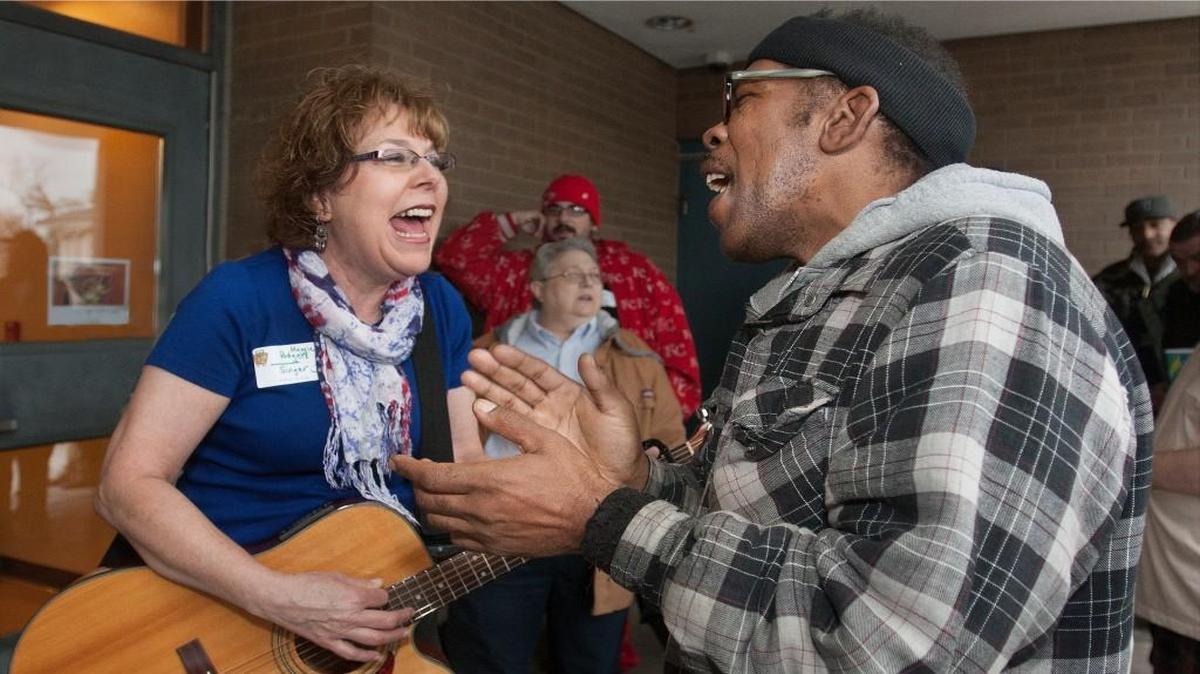 Michael Cahill joined in as volunteer Maggie Rodgers serenaded those at the Salvation Army Linwood Center.