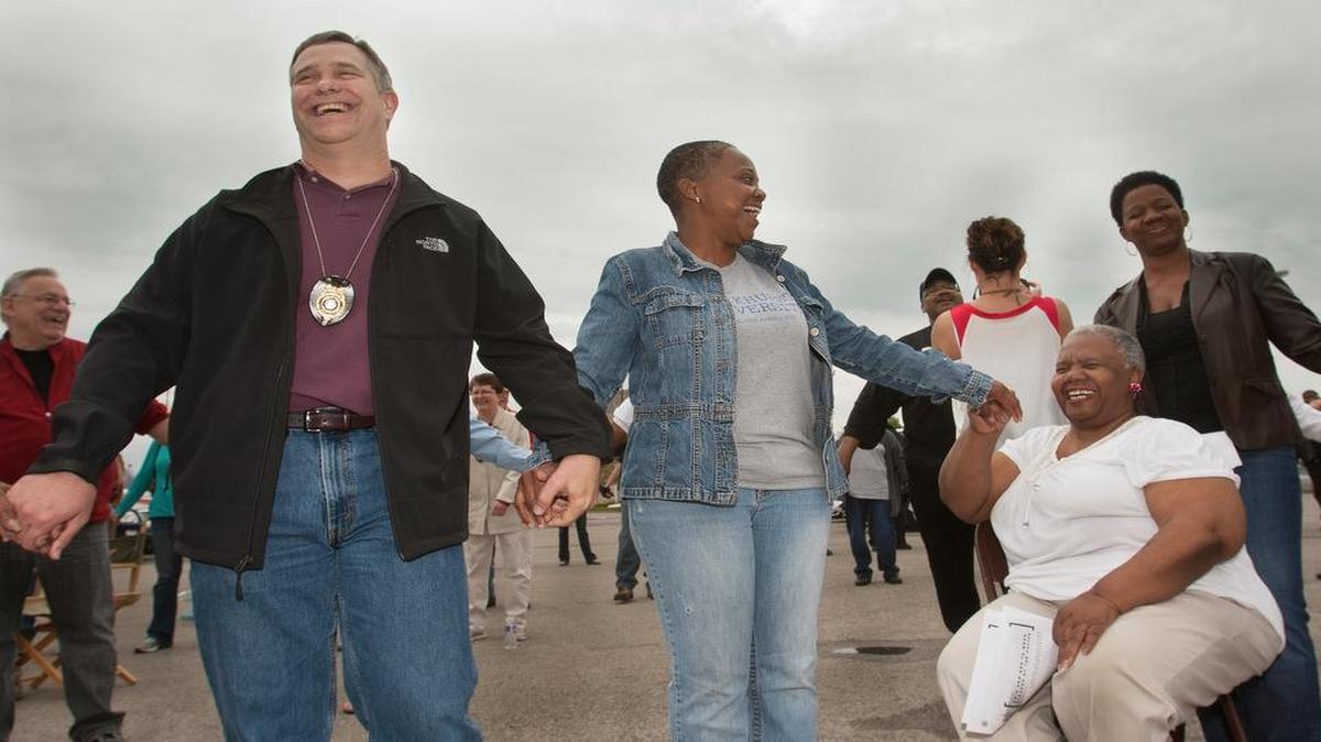 
Kansas City Police Capt. Mark Folsom (from left) Zenja Roe, Joyce Riley (seated) and her daughter Rachel Riley held hands at a peace rally Saturday, showing how relationship-building has helped reduce hostilities between residents and police.
