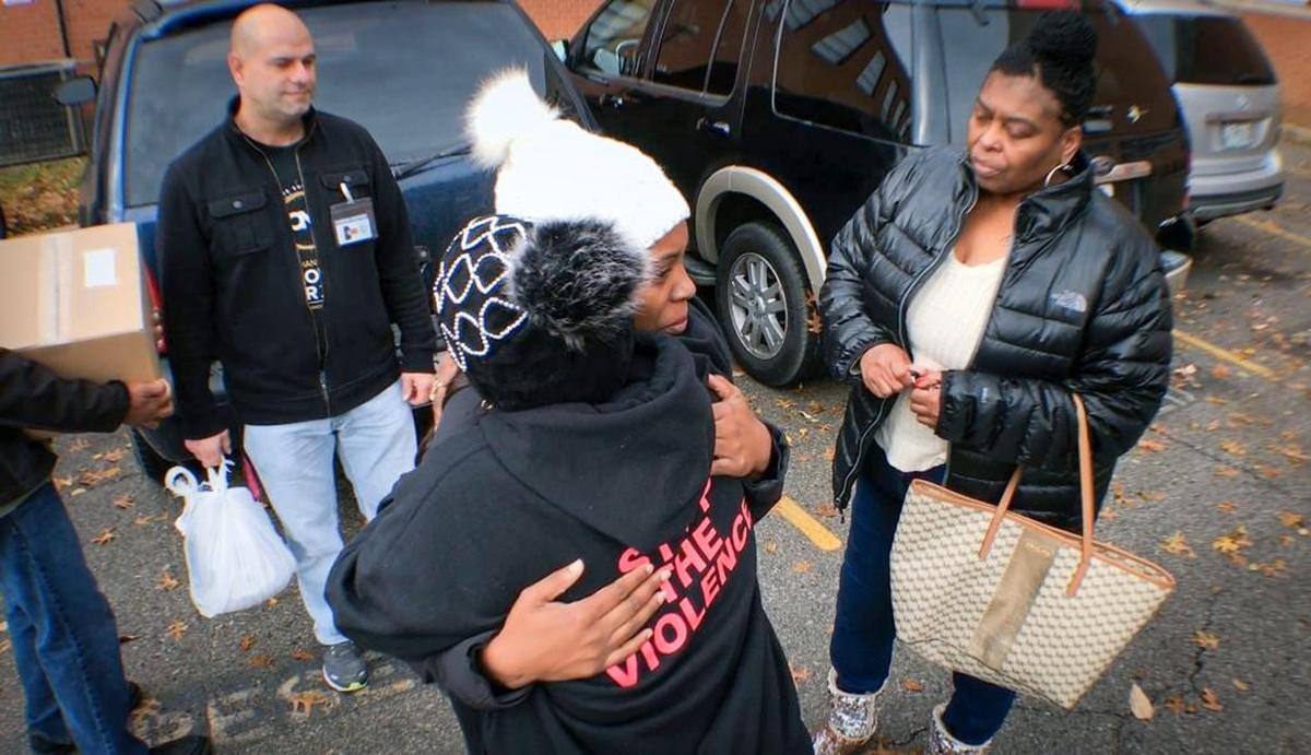 Raeshawn Hamilton (middle), niece of Cortez Hanley, received a hug from a KC Mothers in Charge and World Changers Church of Kansas City volunteer as she and Michelle Miller (right), mother of Cortez, stood in the parking lot after being surprised with Thanksgiving baskets complete with a turkey, sides and a gift card. Fifteen families who lost loved ones in 2017 to homicide received surprise gifts on Saturday, Nov. 18.
