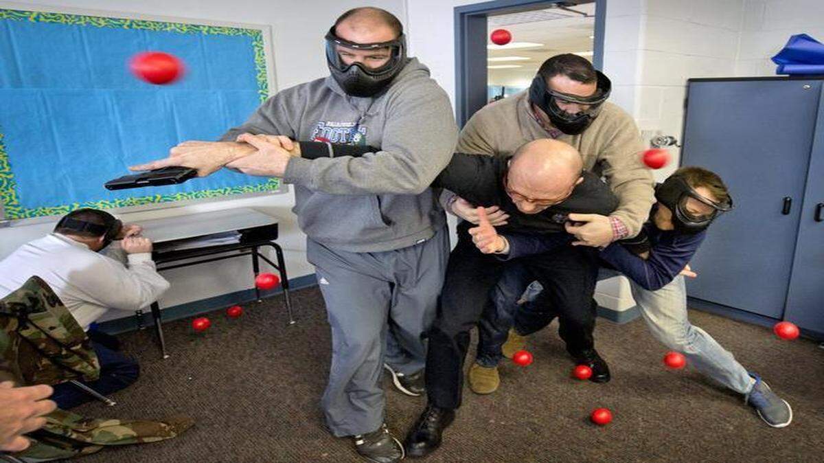
At Pioneer Ridge Middle School on Tuesday, Independence Police Sgt. Chris Summers was swarmed by teacher Cody Carlson (from left), principal Michael Estes and teacher Dave Nowak. Red balls represented objects thrown at the intruder.
