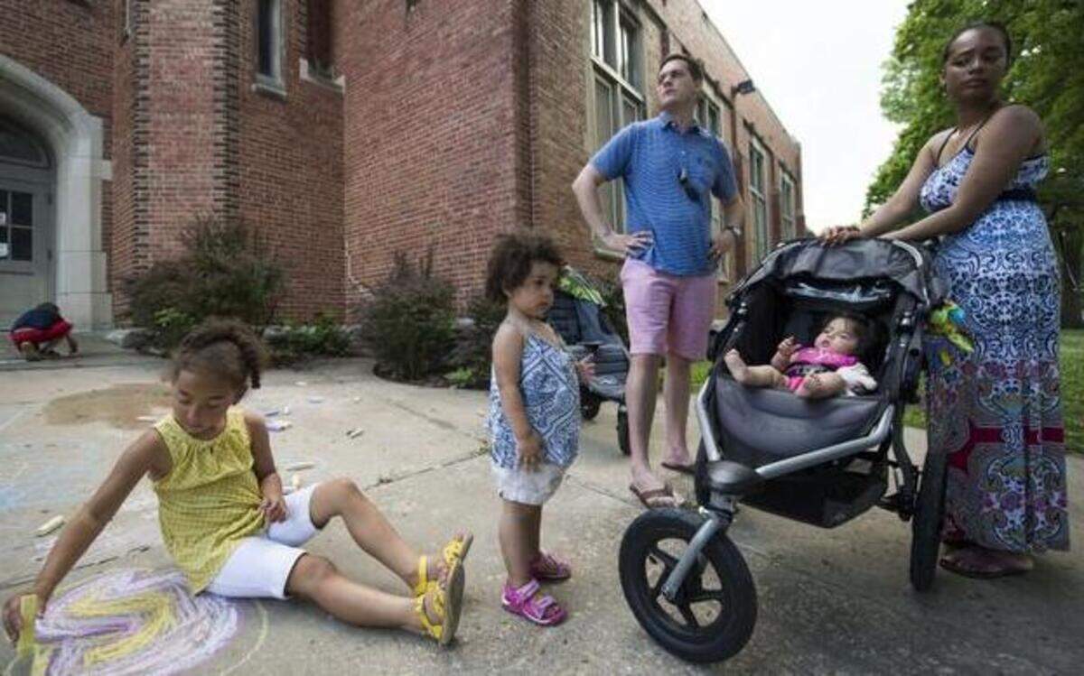 
Lael Ricks, 6, played with chalk on the sidewalk outside of the school as the rest of her family (Avery, 2, father Nick, Valery and mother Liz) watched and listened during a get together for families in the Hale Cook Elementary School neighborhood.
