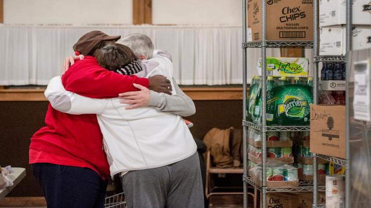
Janice Witt (in red) hugged fellow volunteers Wednesday at the food pantry at Crossroads Family Church, 8822 Parallel Parkway.
