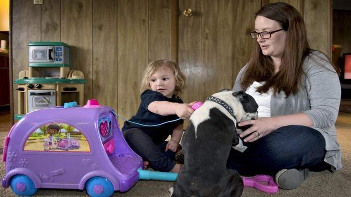 
Marley Martinac, 2, is a kidney patient at Children’s Mercy Hospital, but mom Katie Martinac says the girl is as spunky as ever. Marley used her Doc McStuffins mobile cart to give her dog, Kamo, a checkup at the family’s home in Bates City. 

