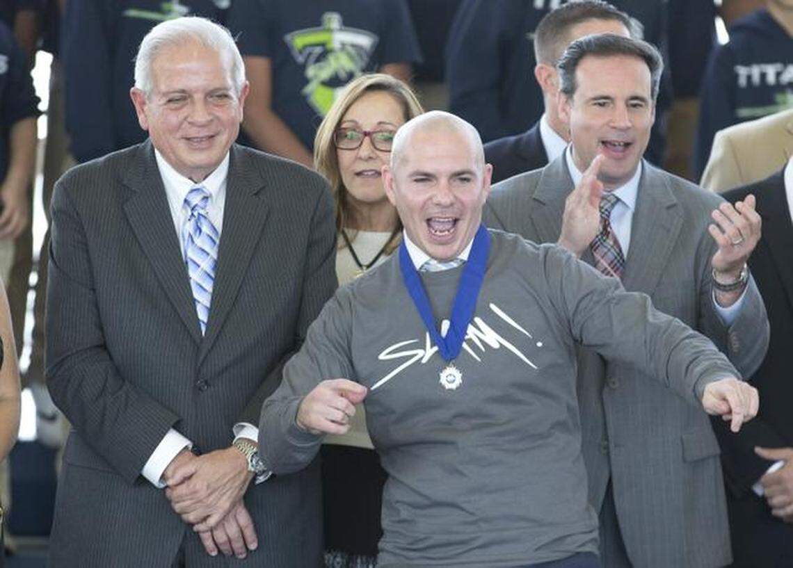 Armando Christian Perez, aka Pitbull, front, cheers as he watches students from Sports Leadership and Management Charter School, SLAM!, perform as they celebrate his birthday, Thursday, Jan. 15, 2015, at the school in Miami. The school received a $1 million to $2 million PPP loan.