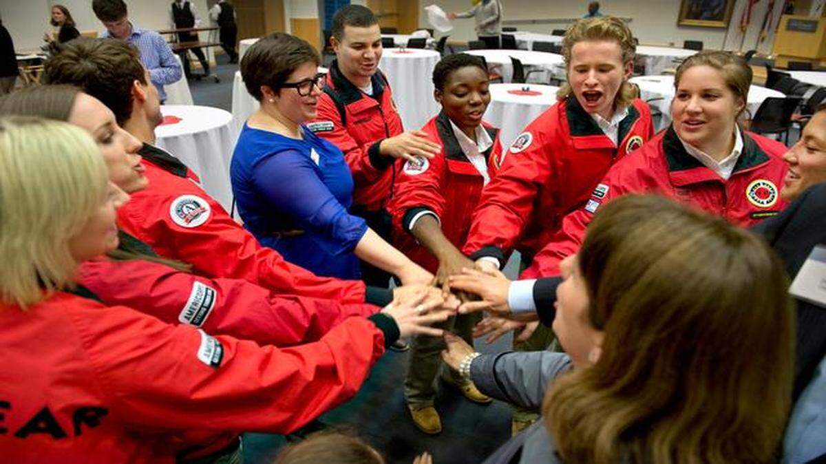 
Red-jacketed workers from the City Year program help various communities. On Monday at the Kauffman Foundation, an information session ended with a “spirit break” involving Jeff Shafer (top, center), a participant who graduated from Lincoln College Prep.
