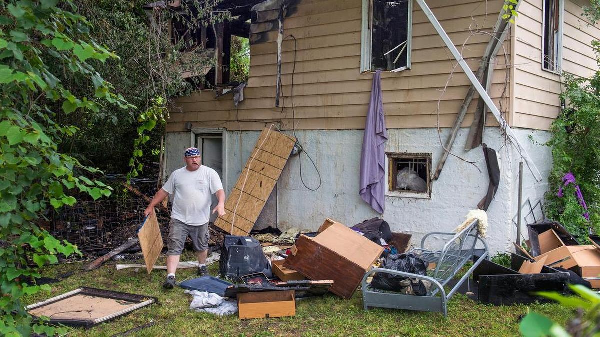 
Bill Brown with Damage Control & Restoration Inc. carried plywood Tuesday to cover the windows of a fire-damaged house in the 4400 block of Elmwood Avenue in Kansas City.
