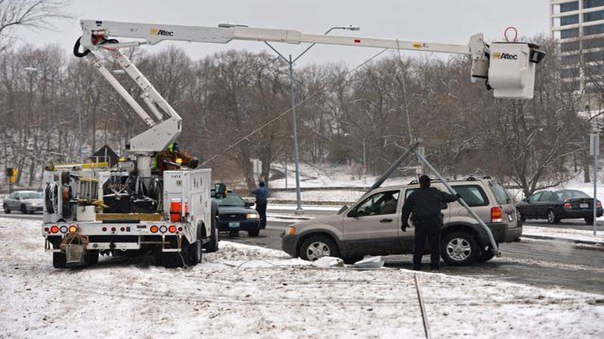 
Kansas City police officer Kenny Miller (left) directed traffic after a vehicle slid into a light pole, knocking it down Saturday on Penn Valley Drive near West 29th Street. Slick streets from falling snow may have contributed to the incident. No injuries were reported.
