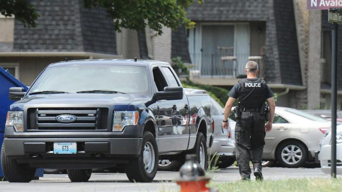 A police officer directed traffic Saturday at Oaks at Prairie View Apartments in Platte Woods during a crime scene investigation.