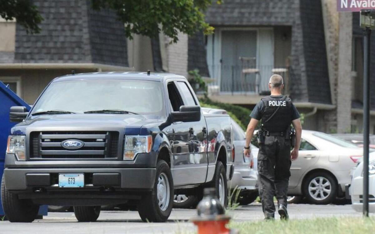 A police officer directed traffic Saturday at Oaks at Prairie View Apartments in Platte Woods during a crime scene investigation.