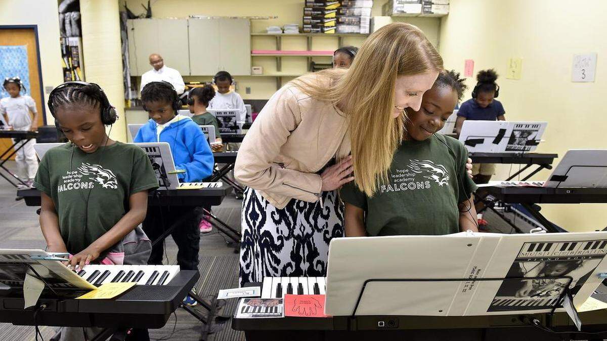 
Last week at Hope Leadership Academy, third-grader Makayla Acklin (left) played keyboard using both hands together for the first time. Jenny Potter, music teacher and grant writer, encouraged ChryShawna Leverette.



