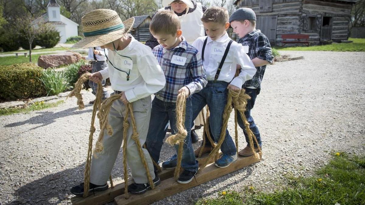 Faith Christian Academy students Oliver Roberts (from left), Judah Gardner, Dallas Campbell and Logan Buckley get a lesson in teamwork while playing a game at Shoal Creek Living History Museum.