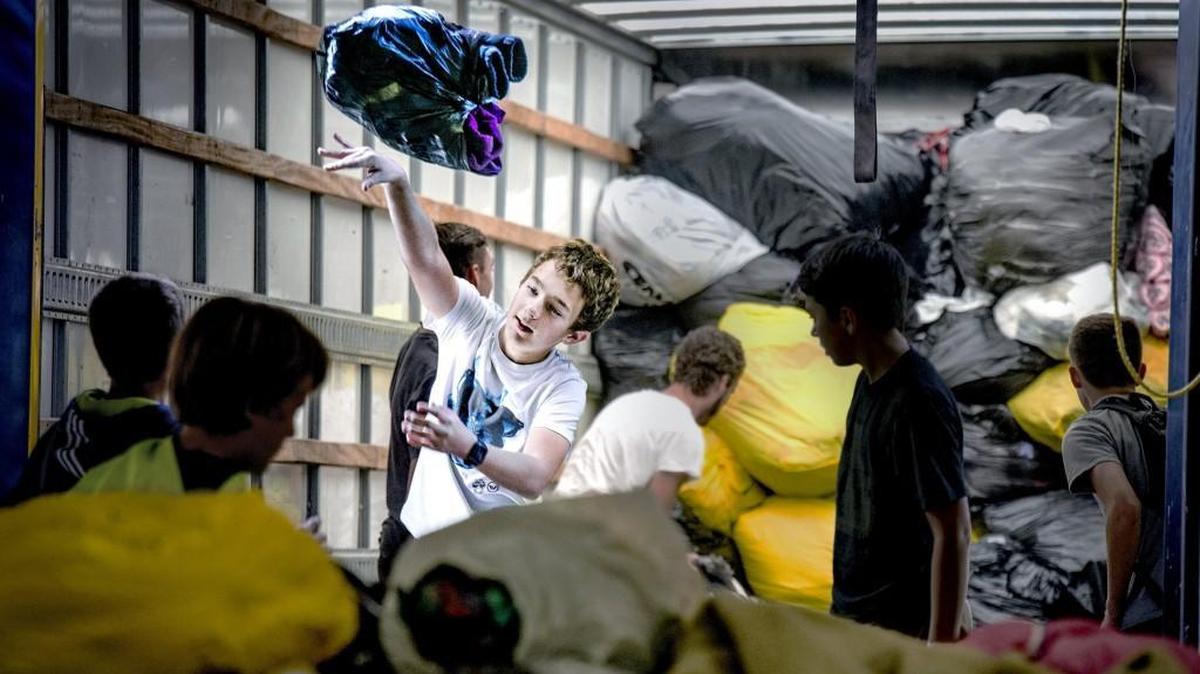 Volunteer Benjamin Zelk of Lee’s Summit tossed bags full of donated items at a Kansas City, Kan., warehouse used by the Salvation Army as a collection site for Project Warmth. There will be eight sites around the metro Saturday, Nov. 4, to collect items for this year’s drive.