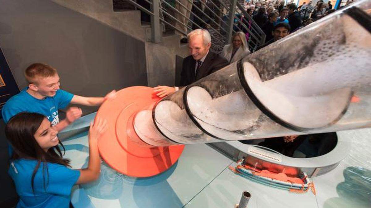 
Marisa Madeira (left), 17, and Cooper Yerby, 18, both Olathe North High School students, take the Archimedes Screw for a spin with Burns & McDonnell CEO Greg Graves during the opening ceremony for their Every Last Drop exhibit.
