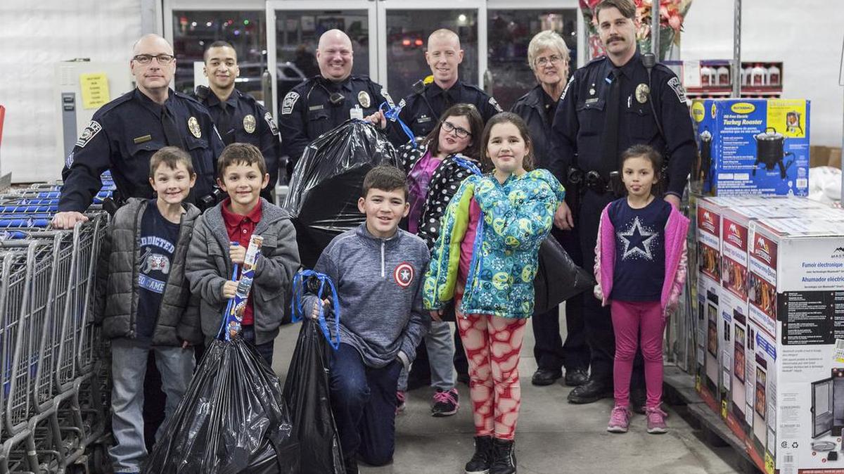 Raymore police officers took 30 children on a shopping trip Dec. 12 at Walmart for the annual Shop with a Cop program. Some of the Raymore police officers who participated in the program posed with their shopping partners (from left to right): Sgt. John Bergman; Officers Nick Jones, Matthew Vellenga and Brent Worthley; Chief Jan Zimmerman; and Officer Jesse Walkingstick.