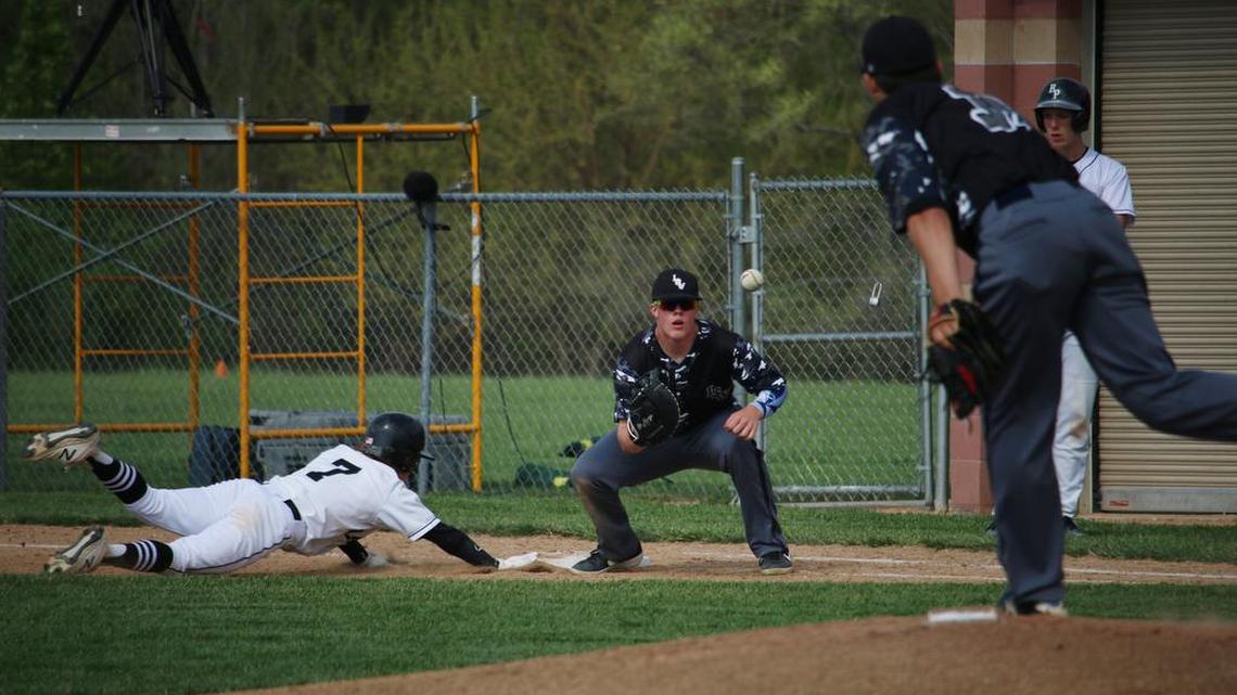 During the junior varsity game, Raymore-Peculiar sophomore Brian Sparks reaches for first base as Lee’s Summit West sophomore Tucker Crain (right) throws to sophomore Brady Rhoden. Ray-Pec won the game 4-3.