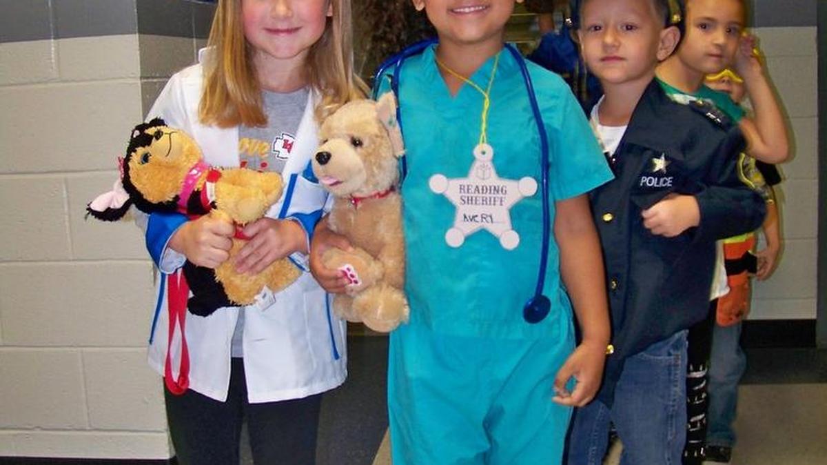 Concluding their unit on doctors, teachers and others who serve the community, kindergarten students participated in a Community Helper Parade. Dressed as their favorite helpers were (from left) Ruthie, Avery and Kayson.