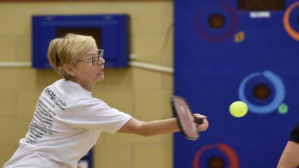 At the Kansas City North Community Center, Susan Rohrmeier returns the ball as teammate Carol Sulack, of Kansas City, North, watches.