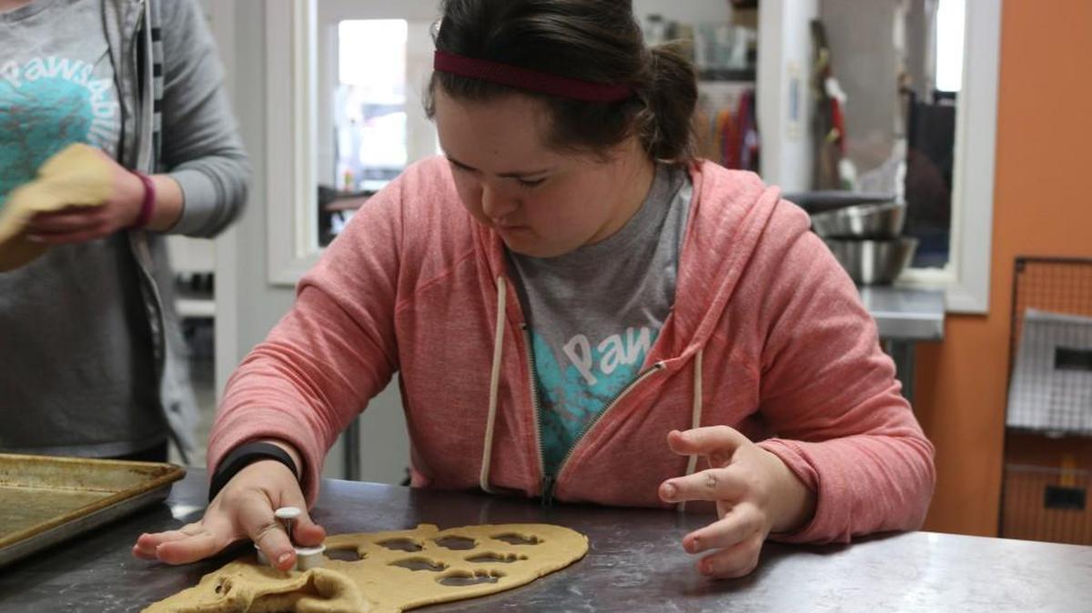 Caroline McVay of Leawood cut out dough for dog treats she helps manufacture at PawsAbilities in Olathe.