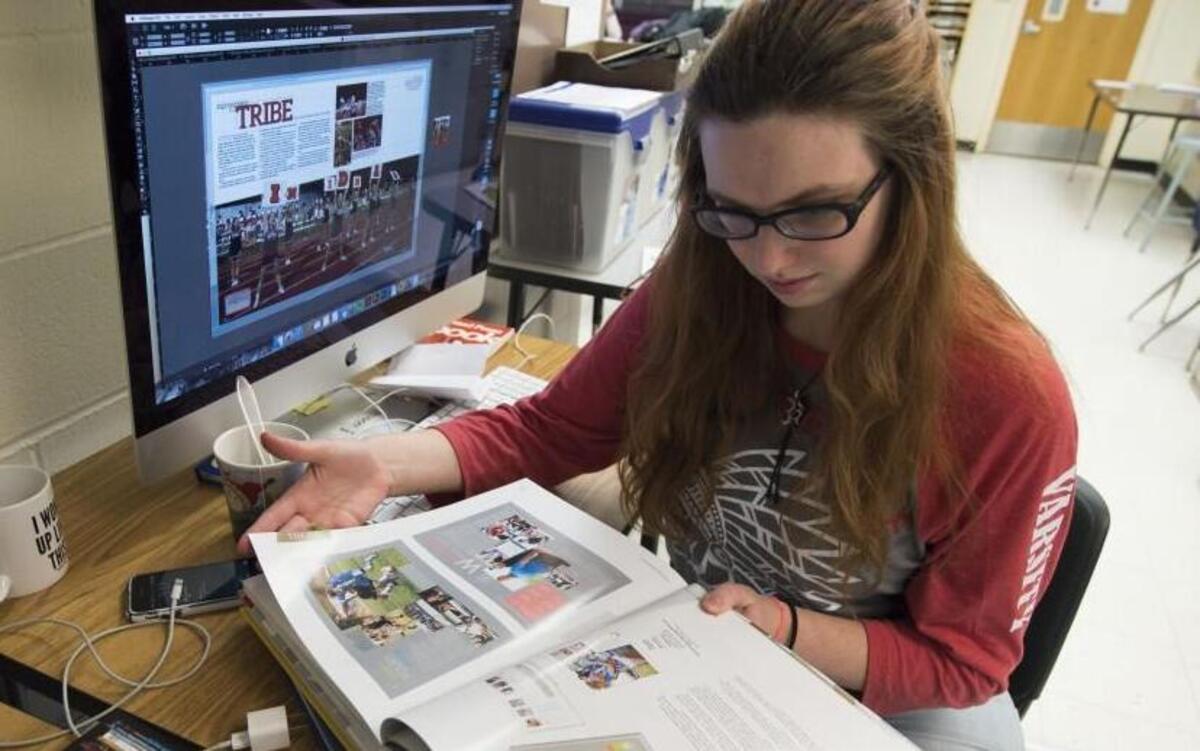The digital era has changed many things, but printed school yearbooks still reign supreme. “It’s exciting to see everyone’s reaction when yearbooks are handed out in May,” says Kylie Cameron, a senior at Shawnee Mission North High School and sports editor for the school’s yearbook, The Indian. Here Cameron leafs through a book for design ideas while working on yearbook pages. The school is in Overland Park.