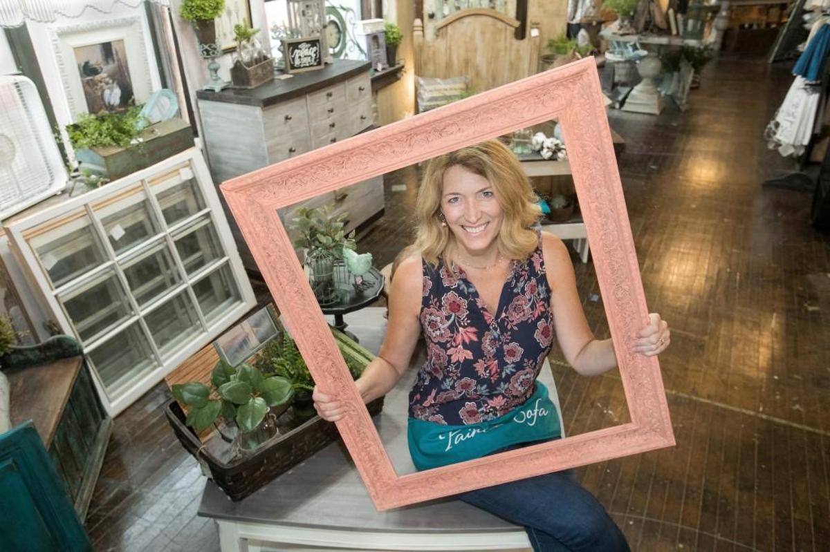 Kayla Becker, a teacher at Pleasant Ridge Middle School, in her vendor booth, Well Traveled Furnishings, at The Painted Sofa, in the West Bottoms.