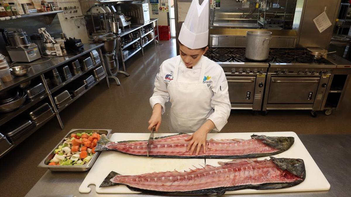 Culinary team member Rocio Ramos butchered a fish in one of the Culinary Academy’s six kitchens.