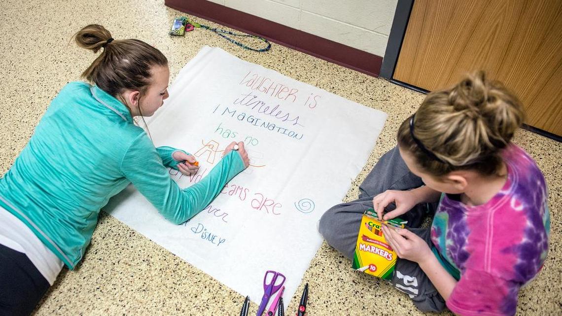 Members of the Keep Frontier Trail Beautiful Club at Frontier Trail Middle School created posters last month. Laughter was the theme of one designed by sixth-graders Aleah Wallace (left), 11, and Josie Murphy, 12.