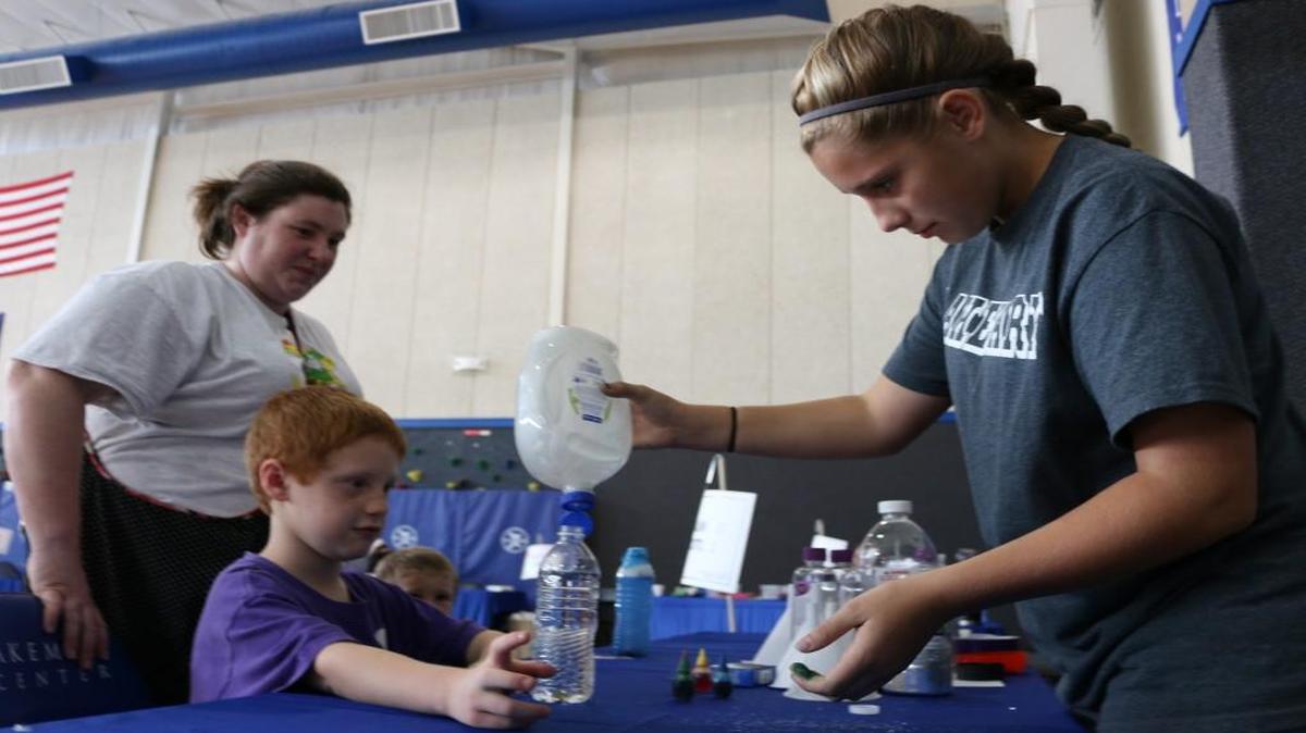 Thirteen-year-old Sierra Bell of Osawatomie, Kan., showed Rachel Ward and her sons Aiden, 7, and Caleb, 3, all of Louisburg, Kan., how to make calming bottles with soap and glitter.