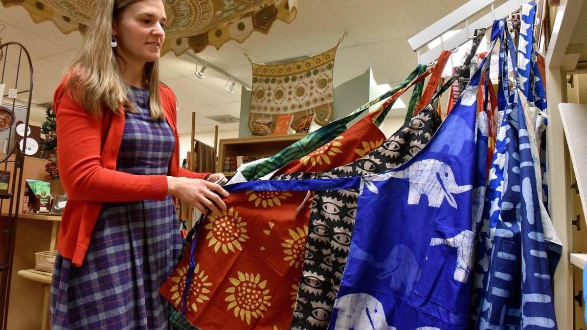 A fair-trade shop called Ten Thousand Villages in downtown Overland Park says its mission is as much about educating the public about fair trade as it is selling the goods the store offers. Store manager Kendra Frink displays handmade aprons made by a group called Global Mamas from Ghana. The shop is at 7947 Santa Fe Drive.