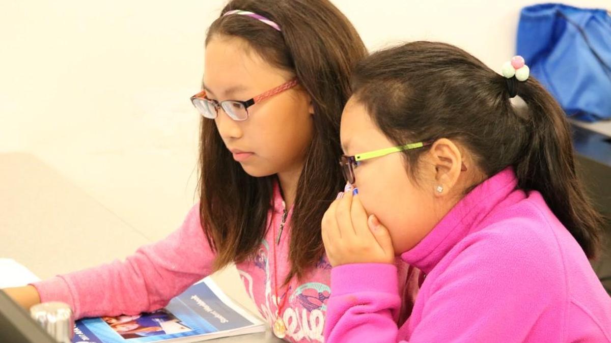 During last Friday’s CyberPatriots’ Youth Cyber Defense Competition, Alina Hau and Soyee Cho, both 11, played the role of new IT professionals tasked with unraveling and finding a solution for their company’s cybersecurity vulnerabilities. The competition was held on the last day of a week-long Cyber Camp hosted by the Olathe Northwest High School CyberPatriots Club.