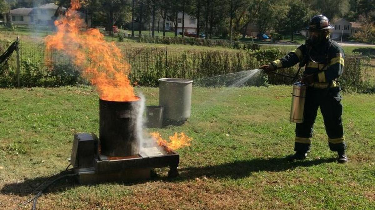 Project Blue Eagle student Reilly Spaits from the Shawnee Mission School District practiced putting out a fire while wearing traditional firefighter gear.