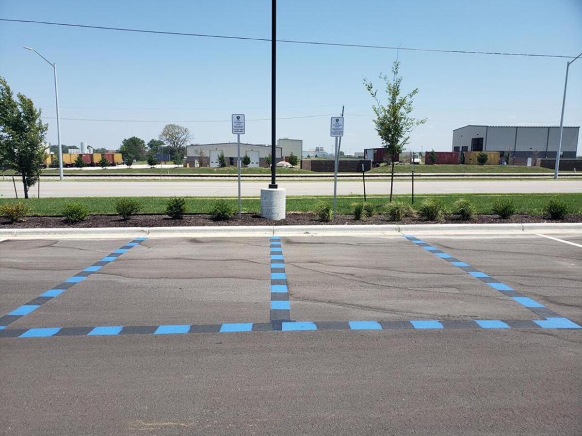 Blue lines and signs designate the parking stalls outside the Gardner Justice Center where people can meet safely to transact business or conduct child custody exchanges.