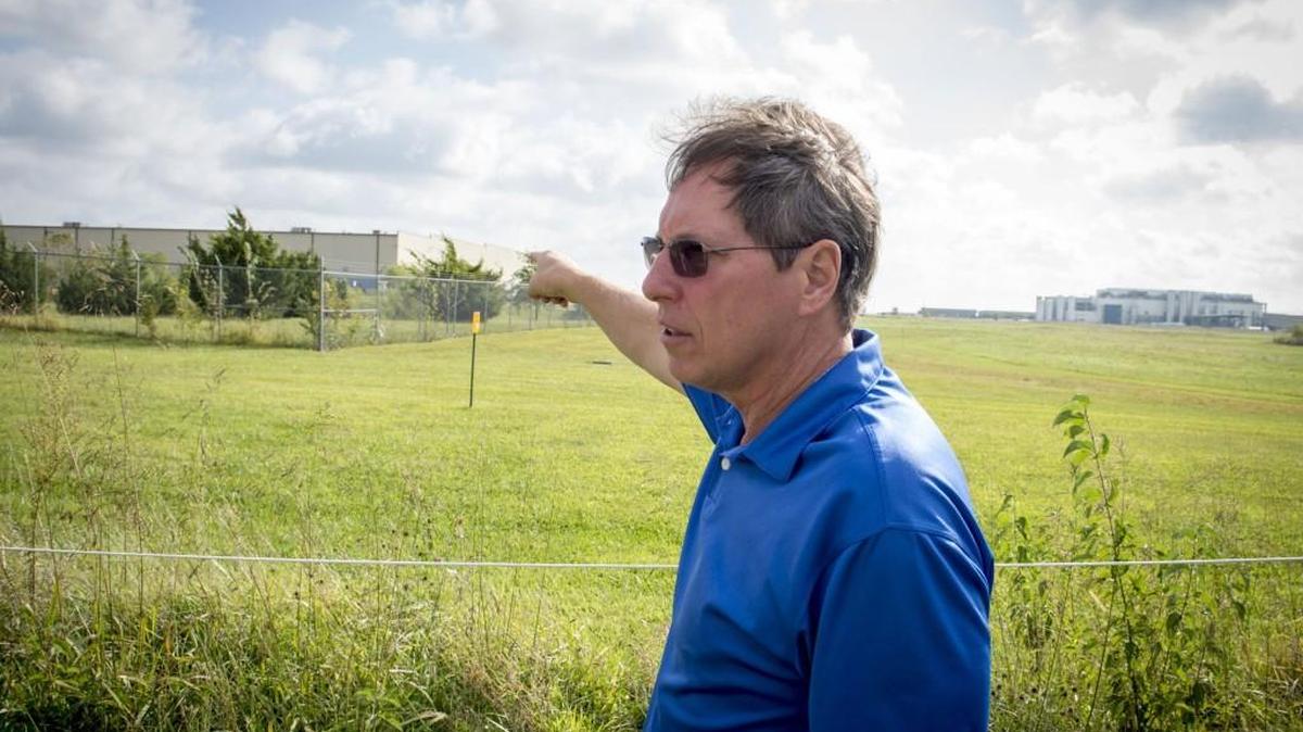 Mike Jensen pointed to the Amazon building as he talked about his battles with Johnson County on Sept. 20, 2017, in Gardner. The county leased the land to a business. He claims that Johnson County and the business did not deliver on promises and assurances involving the height and length of a berm to prevent light pollution and and keep the building out of sight as well as storm water run-off that has dug a gulley on his property and silted in his pond.