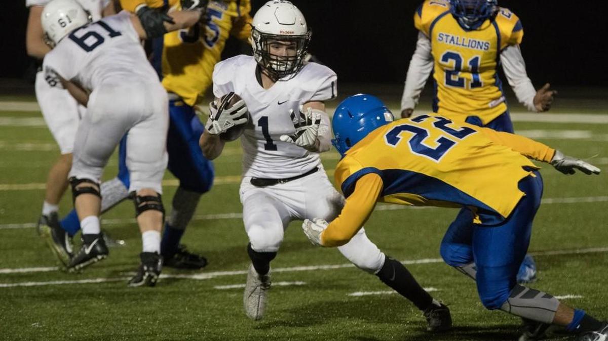 Mill Valley running back Cameron Young slips past a Schlagle defender on his way to the end zone in a Class 5A playoff game Nov. 3 at Schlagle. Young rushed for 139 yards and four touchdowns in the Jaguars’ 57-12 victory.