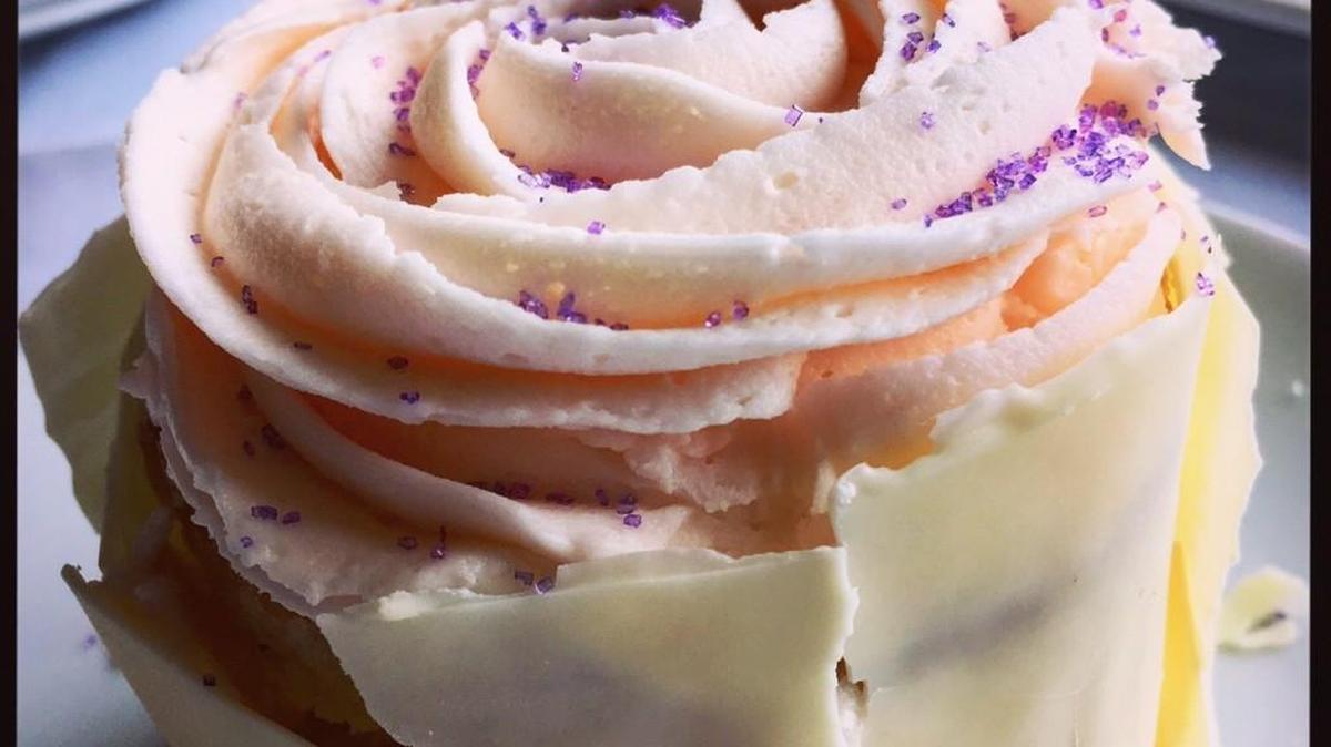 The Dessertery’s Champagne cake is topped with a piped pink flower and wrapped in a white chocolate ribbon.