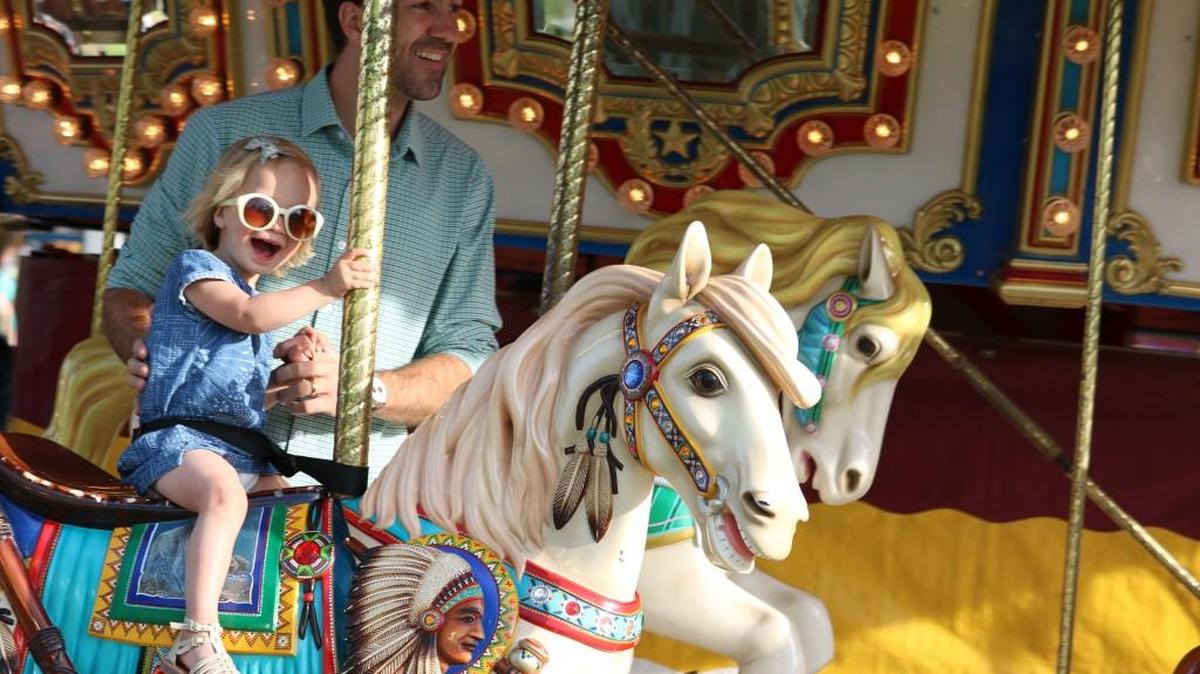 Emerson Ilten, 2, was in bliss during a carousel ride with her father, Chase, on Friday evening at Old Shawnee Days. Related story and photos, Page 3