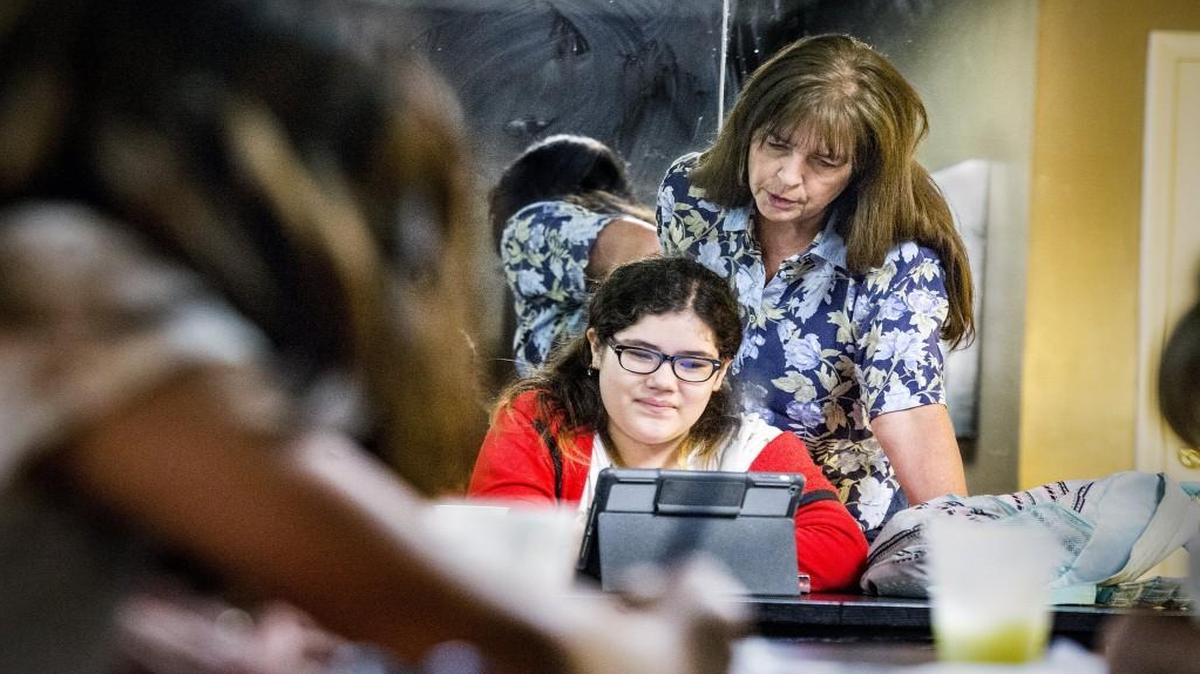 Trudy Stockwood (standing) helps fifth grade student Luci Reyes, 10, with with her homework at Lenexa Pointe Apartments. Stockwood works with a homework help program for elementary and middle school students sponsored by the Lenexa Baptist Church.